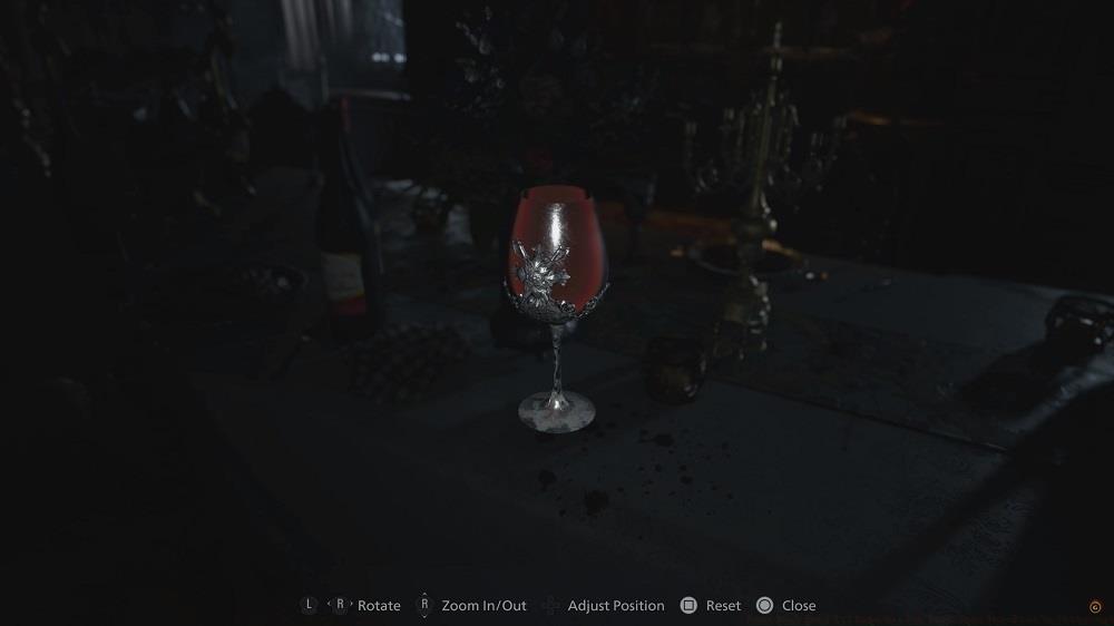 Examine the wine glass in the room with the open window to find a ring with a round maroon eye inside.