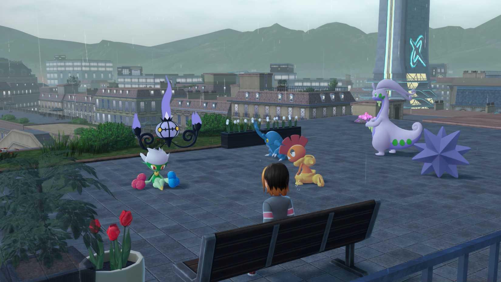 A team of Pokémon including a Goodra sits together in the rain on a rooftop.